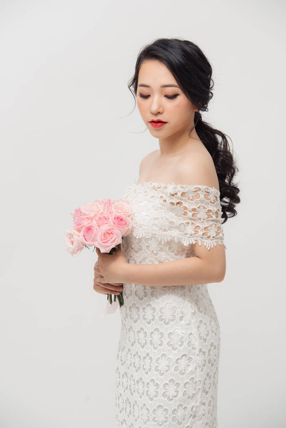 Fashion portrait of elegant woman with rose flower bouquet over white background. - 写真・画像