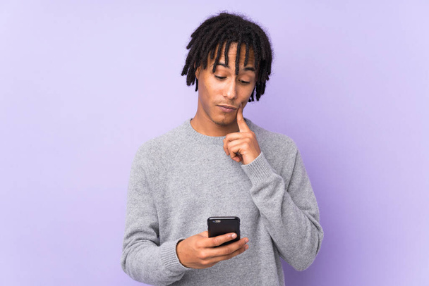 Young african american man isolated on purple background thinking and sending a message - Fotografie, Obrázek