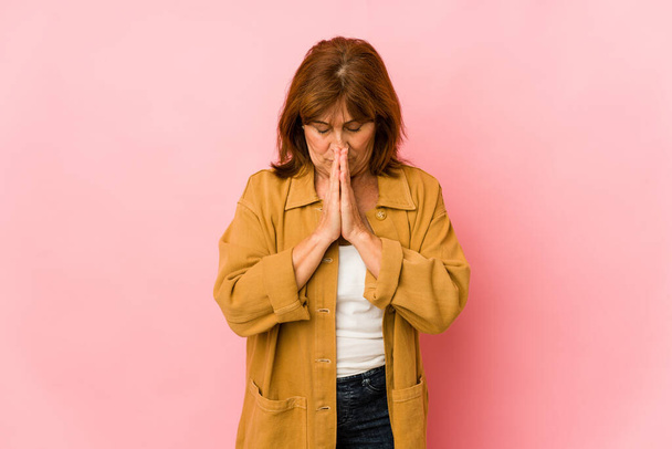Mujer caucásica mayor aislada orando, mostrando devoción, persona religiosa buscando inspiración divina. - Foto, Imagen