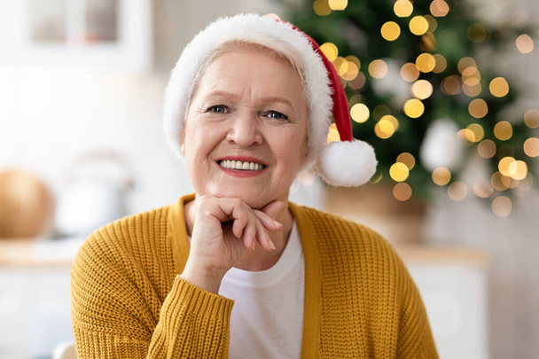 Portrait of cheerful old woman in Santa hat - Foto, imagen