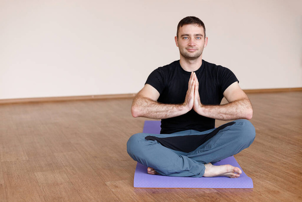 a man in a lotus pose makes a namast with his hands - Foto, imagen