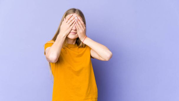 Young blonde woman isolated on purple background afraid covering eyes with hands. - Foto, immagini