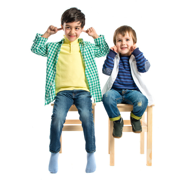 Boys covering his ears over white background.  - Photo, Image