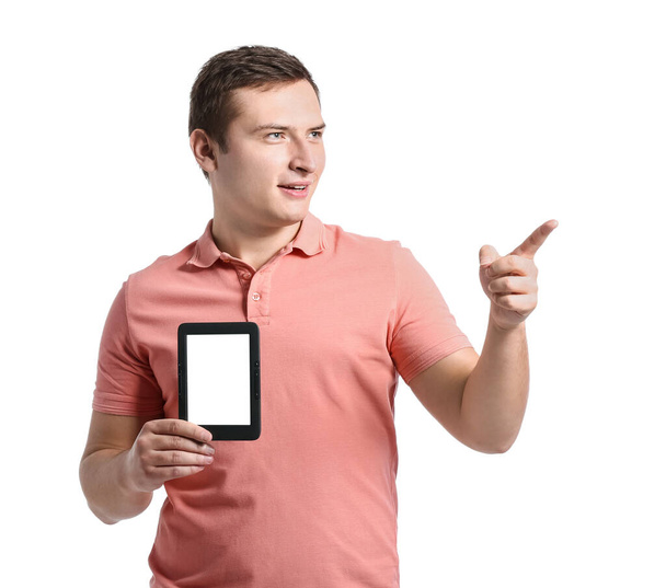 Jongeman met e-reader wijst naar iets op witte achtergrond - Foto, afbeelding