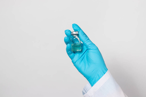 Een arts of laboratoriumtechnicus houdt een injectieflacon met een vaccin vast. Vaccinatie tegen tuberculose, rabiës, tetanus en andere infectieziekten. Mazelen, Rodehond, Polio, Preventie. - Foto, afbeelding