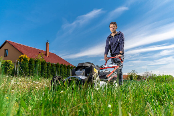 cortador de motor para cortar o gramado ao lado da casa da família - Foto, Imagem