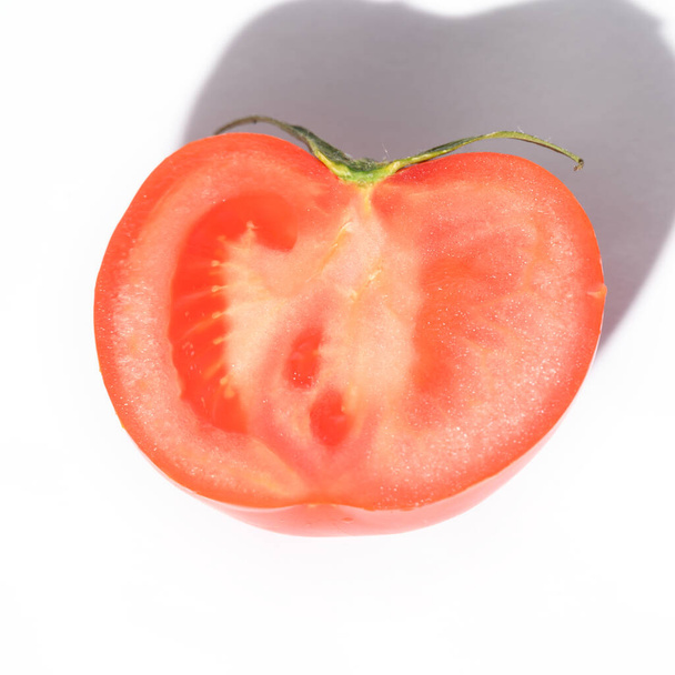 нарезанный свежий спелый помидор на светлом фоне, близкий вид - Фото, изображение