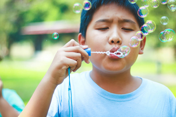 Мальчик надувает пузыри в саду - Фото, изображение