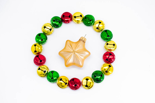 Барвисті дзвінкі різдвяні дзвіночки в золоті, червоному і зеленому. У формі кола з золотими зірками різдвяної прикраси посередині. Концепція Різдва. Свято фону
. - Фото, зображення