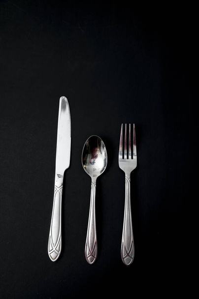 A vertical shot of knife, spoon, and fork - Foto, afbeelding