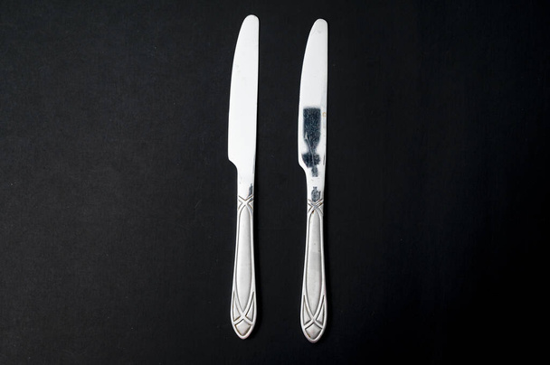 Una vista superior de los cuchillos de mesa sobre un fondo negro - Foto, Imagen