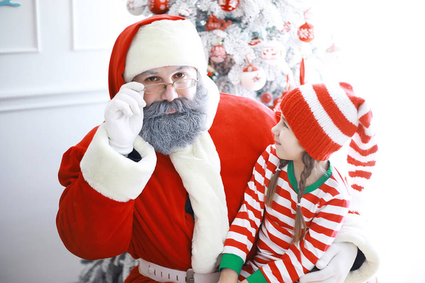 Santa Claus pomocníci.Roztomilé děti v kostýmech vánočních skřítků v pokoji krásně zdobené na Vánoce. Čas zázraků. Dárky od Santa Clause - Fotografie, Obrázek
