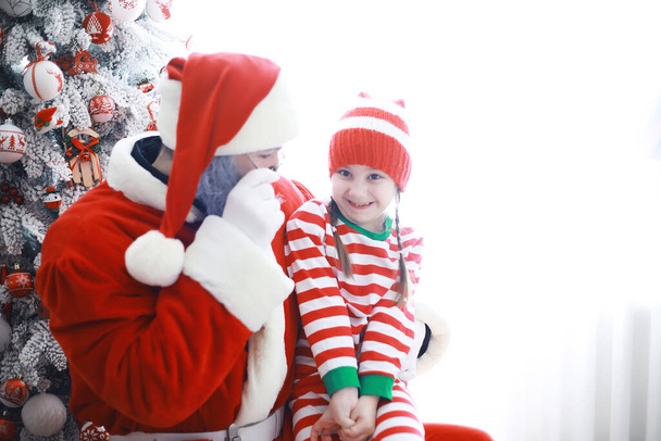 Santa Claus's helpers.Cute children in christmas elf costumes in a room beautifully decorated for Christmas. Time of miracles. Gifts from Santa Claus - Photo, Image