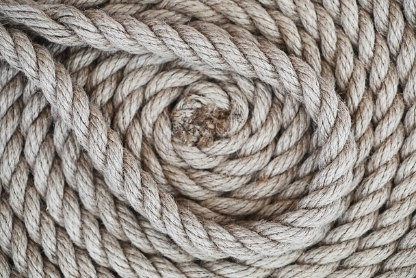 Gevlochten dik touw vastgebonden in een streng. Hennep touw voor decoratie en design. Achtergrond van het vistouw. - Foto, afbeelding