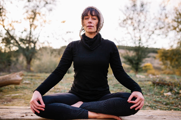 Egy nő, aki jógázik és meditál a parkban. - Fotó, kép