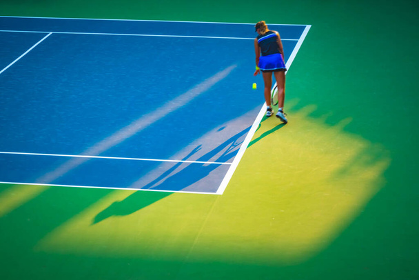 молодая женщина играет в теннис на корте - Фото, изображение