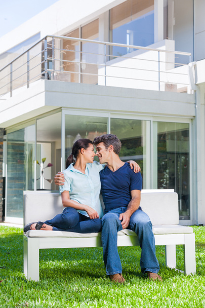 Couple assis devant une grande maison moderne
 - Photo, image