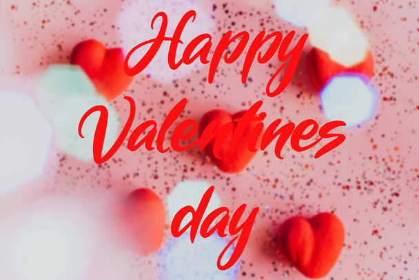 Boldog Valentin napi szöveg elmosódott rózsaszín háttér szívvel. - Fotó, kép
