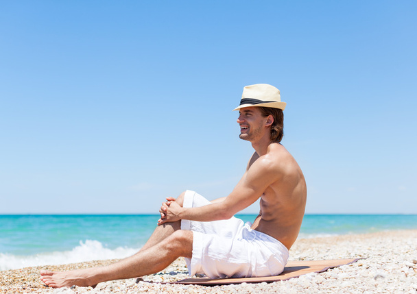 Man sitting on beach - Фото, изображение