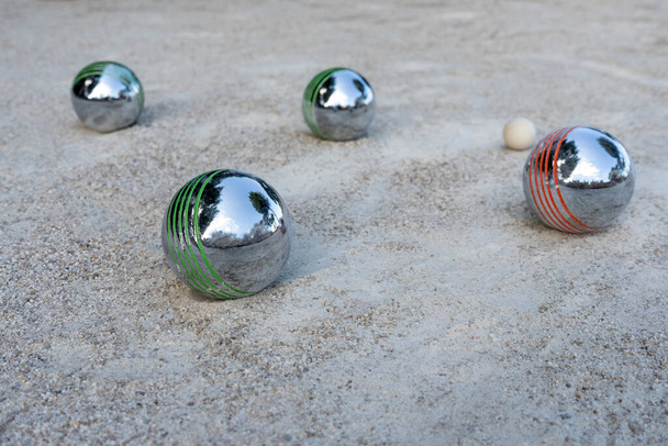 Close-up of steel balls for petanque on a gravel surface, France. Selective focus - Fotografie, Obrázek