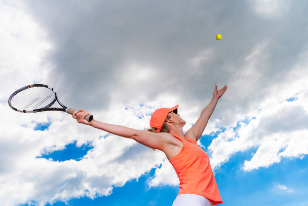 τένις σερβίρεται από μια νεαρή γυναίκα στο γήπεδο - Φωτογραφία, εικόνα