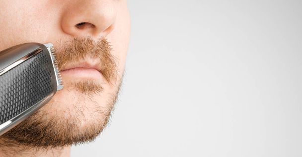 Shaving of mustache with electric razor or trimmer with copy space - Fotoğraf, Görsel