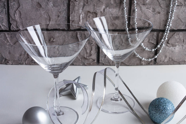beautiful christmas decor in silvery gold tones, empty martini glass, christmas toys on a concrete background - Photo, Image