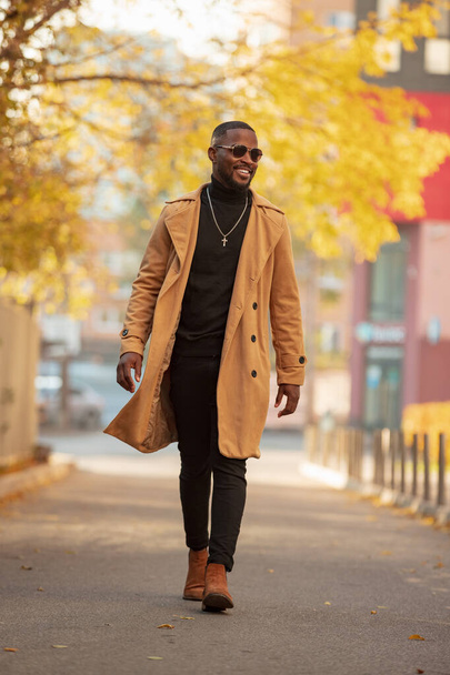 Stylish African American man walking in the autumn city - Фото, зображення