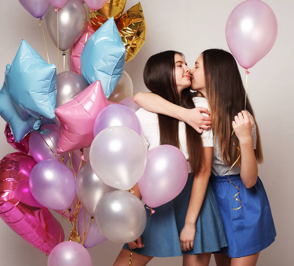 lifestyle and people concept: two girls friends with colorfoul air balloons - Fotoğraf, Görsel