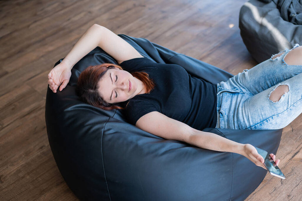 Caucasian young woman sleeping on bean bag - Foto, afbeelding