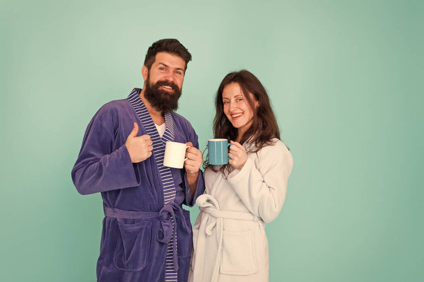 Drinking coffee. Brewing coffee at home. Hot drink. Coffee is our tradition. Man and woman happy together. Family traditions. Daily life and routine. Couple in cozy bathrobes enjoy lazy weekend - Foto, imagen