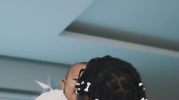 Jouluna monirotuisessa perheessä. Afrikkalainen amerikkalainen musta isä nostaa hänen mulatto vauva lähellä joulukuusi - Materiaali, video