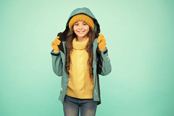 Christmas vacation. warm clothes sales. happy girl blue jacket. Winter holidays. knitted clothes fashion. cold season weather. outdoor activity for kids. small girl sweater. hat and gloves accessory - 写真・画像