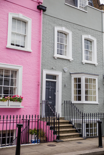 Pink and gray British houses with flowers outside the window and handrails - Photo, Image