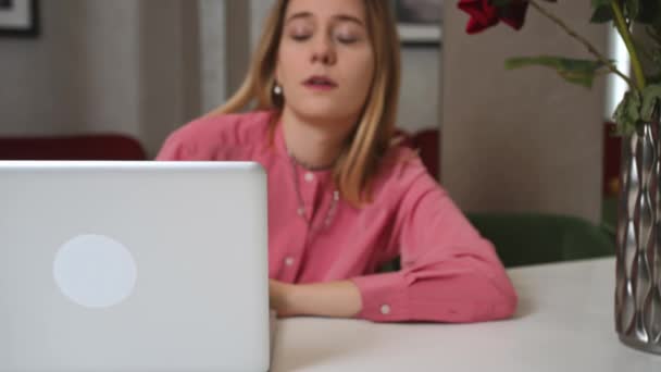 Müde junge Frau arbeitet im Homeoffice am Laptop. fällt mit dem Gesicht nach unten in einen Desktop. Frau bei der Arbeit ausgebrannt. - Filmmaterial, Video
