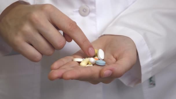 Painkiller pill, Antibiotics pill, Muscle Dehydration pill, Swelling pill and Calcium tablet in the palm for spine subsidence. Holding painkiller pills on hand - pharmacy and treatment concept - Footage, Video