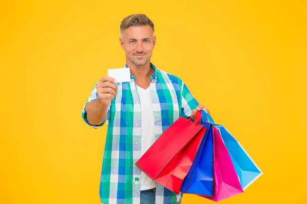 holiday flash sale and special offer. cyber monday in shop. customer. successful male shopping. man with paperbags show business or credit card. purchase in paper bags. guy hold gift. Clothing store - Zdjęcie, obraz
