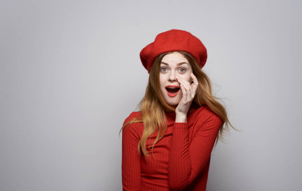 mooie vrouw in rode jurk glamour hoed emoties verrast blik - Foto, afbeelding