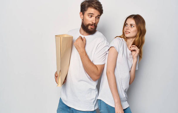 Fröhliches Ehepaar T-Shirts-Paket in den Händen eines Mannes Einkaufen ist Freude - Foto, Bild