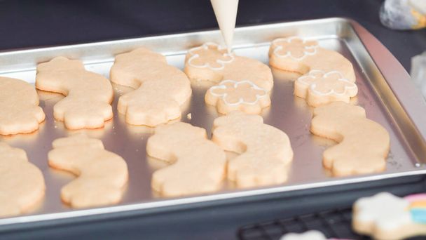 Step by step. Decorating unicorn sugar cookies with royal icing on baking sheet. - Photo, Image