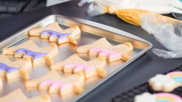 Paso a paso. Decoración de galletas de azúcar unicornio con glaseado real en bandeja para hornear. - Foto, imagen