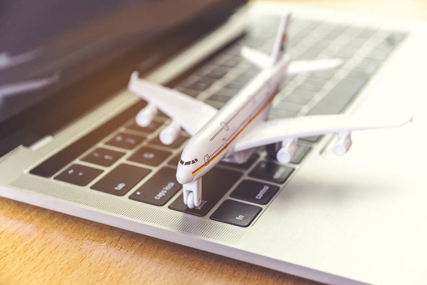 Laptop und Flugzeug auf dem Tisch. Online-Ticketbuchungskonzept - Foto, Bild