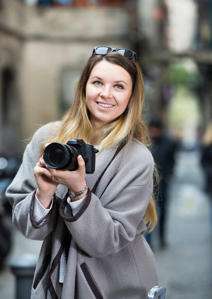 Young woman looking curious and taking pictures - Foto, imagen