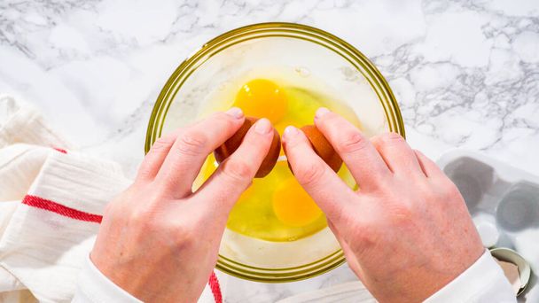 Βήμα-βήμα. Επίπεδη. Ανακατεύοντας τα συστατικά σε ένα γυάλινο μπολ ανάμιξης για να προετοιμάσει μπέικον και τυρί κέικ αυγών. - Φωτογραφία, εικόνα
