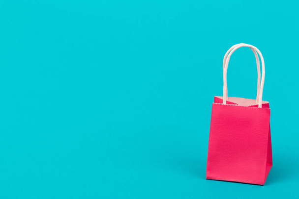 Papier cadeau roze tas close-up op mooie blauwe achtergrond met kopieerruimte. Verkoop- en winkelconcept. - Foto, afbeelding
