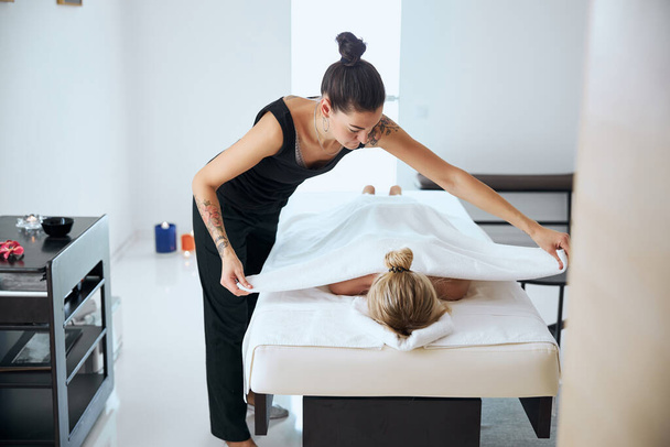 Beautiful massage therapist finished aroma treatment in spa center - Foto, imagen