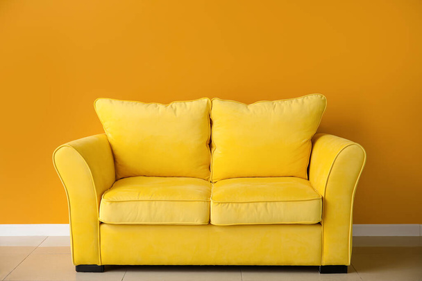 Stylish sofa near color wall in room - Photo, Image
