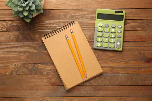 Modern calculator and stationery on wooden background - Photo, Image