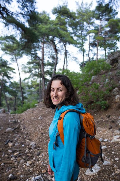 バックパック付きの女の子は、森林歩道、トルコの観光スポット、絵のように美しい場所を旅し、トレッキング、ハイキング、女性は観光ルート、山道を歩く. - 写真・画像