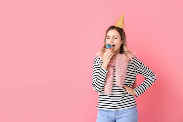 Hermosa mujer joven con cupcake de cumpleaños en el fondo de color - Foto, imagen
